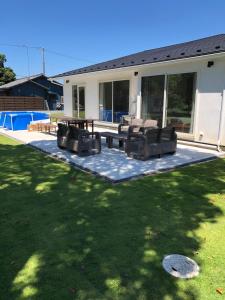 a patio with chairs and a table in a yard at ダブルレインボー一宮 in Ichinomiya