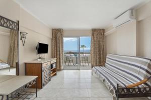 een slaapkamer met een bed, een televisie en een balkon bij Santa María in Adeje