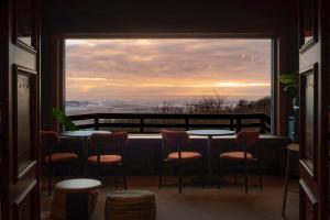 a balcony with tables and chairs and a large window at Hostellerie Kemmelberg in Kemmel