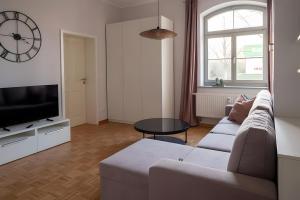 a living room with a couch and a tv and a table at Ferienwohnung Lindner 2 in Weimar