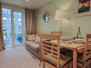 ein Wohnzimmer mit Tisch und Couch in der Unterkunft Cherry Pip in Charmouth