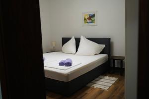 a bedroom with a bed with white sheets and pillows at Apartmani Dusper in Vodice
