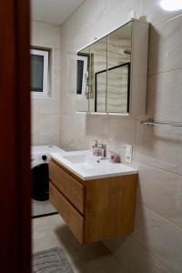 a bathroom with a white sink and a mirror at Apartmani Dusper in Vodice