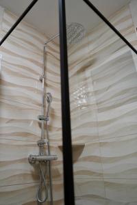 a shower with a shower head in a bathroom at Apartmani Dusper in Vodice