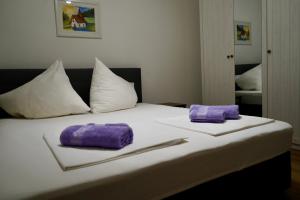 a bed with two purple napkins on top of it at Apartmani Dusper in Vodice +17 photos