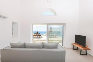 a living room with a couch and a television at D & G Private Villas in Agios Georgios Pagon