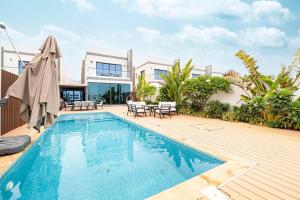 a swimming pool in front of a house at Luxury Villa sea view and free paddle boat - Al Dana Island Fujairah in Fujairah