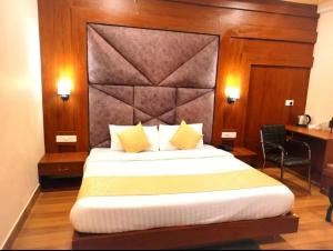 a bedroom with a large bed and a desk at ECKO Vasudeva in Pāndukeshwar