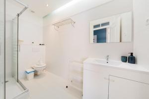 een witte badkamer met een wastafel en een toilet bij Bright 3BR Steps from National Pantheon | By Airnest in Lissabon