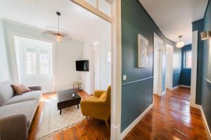 een woonkamer met een bank en een tafel bij Bright 3BR Steps from National Pantheon | By Airnest in Lissabon