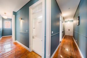 een gang met blauwe muren en een witte deur bij Bright 3BR Steps from National Pantheon | By Airnest in Lissabon +40 foto's