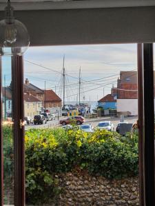 a view of a harbor from a window with a ship at AnchorageWells Entire Cottage OR a King Ensuite on Room Only in Wells next the Sea +68 photos