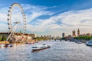 a ferris wheel and a boat on a river with a city at Family Friendly 3 Bedrooms Flat in Central London in London
