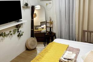 une chambre avec un lit et une télévision sur un mur dans l'établissement Balinest Studio Tagaytay, à Tagaytay