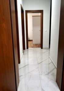 an empty hallway with white marble floors and doors at Apartmani Dusper in Vodice