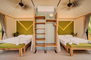 two bunk beds in a room with a ladder at Evia Life Resort in Puerto Viejo +60 photos