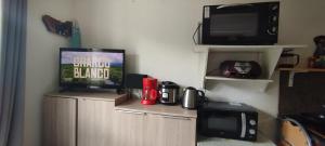 a room with a television and a microwave at Studio calme in Saint-Nazaire