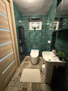 バーミンガムにあるCozy Studio in Birmingham Kingstandingの緑のタイル張りのバスルーム(トイレ、シンク付) +19枚の写真