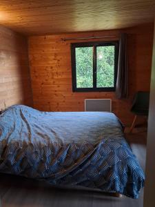 une chambre avec un lit dans une cabane en bois dans l'établissement Gîte Les Balcons des usses, à Frangy