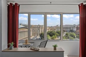 a room with a table and a window with a view at Quiet Apartment Ruby Horizon in Bucharest +18 photos