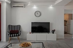 a living room with a tv and a chair at Quiet Apartment Ruby Horizon in Bucharest