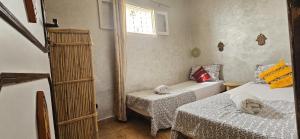 a small room with two beds and a window at Idriss Seaview Guesthouse in Taghazout