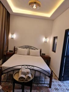 a bedroom with a bed and a table with towels on it at Riad Dar Fatna in Marrakesh