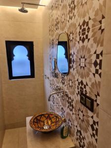 a bathroom with a sink and a mosaic wall at Riad Dar Fatna in Marrakesh +106 photos