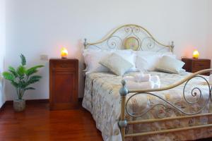1 dormitorio con 1 cama con 2 velas encendidas en Relax Merigge - Piscina a Comune - Parcheggio, en Pieve a Maiano 40 fotos más