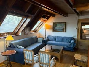 a living room with a blue couch and a table at Dúplex elegante de montaña con vistas y confort - Erta 6 in Pla de l'Ermita