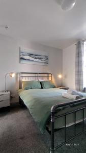a bedroom with a large bed with green sheets at OYO Shore Surf Lodge in Newquay