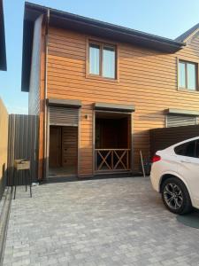 a house with a car parked in front of it at Тиха Хвиля in Gribovka