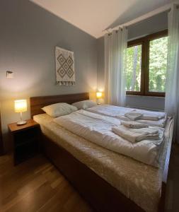 Ένα ή περισσότερα κρεβάτια σε δωμάτιο στο Apartament z ogródkiem, basen, garaż, Villa 4 Pory Roku