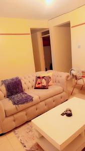 a living room with a couch and a coffee table at Bustani Homes apartment in Kahawa