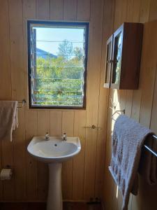 een badkamer met een wastafel en een raam bij Wilderness Views - Clermont Cottage in Wilderness +8 foto's