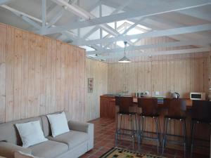 ein Wohnzimmer mit Couch und Bar in der Unterkunft Wilderness Views - Clermont Cottage in Wilderness