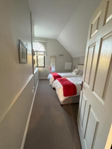 1 dormitorio con 2 camas y mantas rojas en Apartment 1 - Rivervilla or Apartment 2 - Stone Cottage, en Underberg