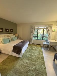 Un dormitorio con una cama grande y una ventana grande. en Apartment 1 - Rivervilla or Apartment 2 - Stone Cottage, en Underberg