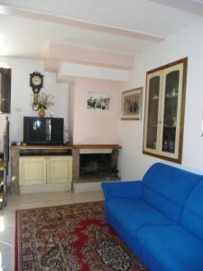 a living room with a blue couch and a tv at Casa Filomena in Tramonti