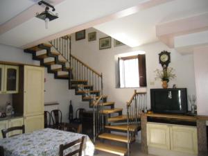 a living room with a spiral staircase and a television at Casa Filomena in Tramonti