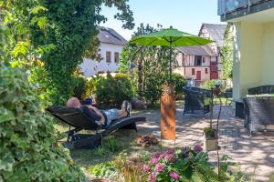a person laying in a chair under an umbrella in a garden at Ferienwohnung Andrea in Pohl