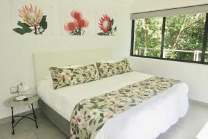 a white bedroom with a bed and a window at Pecan Tree Forest Studio A with Terrace in Stellenbosch