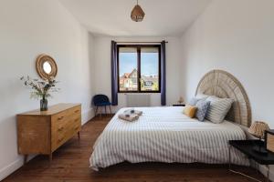 a bedroom with a large bed and a window at L'impasse - Maison avec jardin proche du centre in Rouen