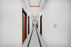 a corridor in a house with white walls and ceilings at Collection O Whitefield Railway Station Kadugudi Whitefield in Bengaluru