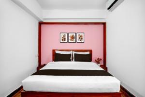 a bedroom with a large bed with a pink wall at Collection O Whitefield Railway Station Kadugudi Whitefield in Bengaluru