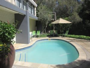 a large blue swimming pool next to a building at Pecan Tree Forest Studio A with Terrace in Stellenbosch +76 photos