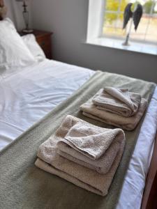 two folded towels are sitting on a bed at Guisborough 3-Bed, with parking, Walk to Pubs, Shops & Trails in Guisborough