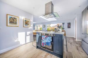 a kitchen with a blue island in a room at Windrocks - Bracklesham Bay in Chichester