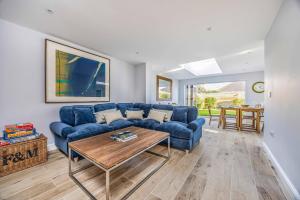a living room with a blue couch and a table at Windrocks - Bracklesham Bay in Chichester