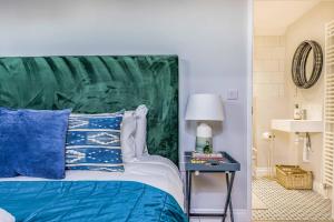 a bedroom with a bed with a green headboard at Windrocks - Bracklesham Bay in Chichester